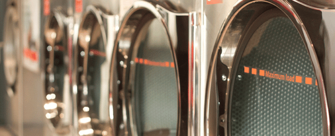 Four washing machines in a row prepared for maximum load.