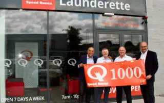 People celebrating in front of a Speed Queen laundry store the 1,000th opening in Ireland.